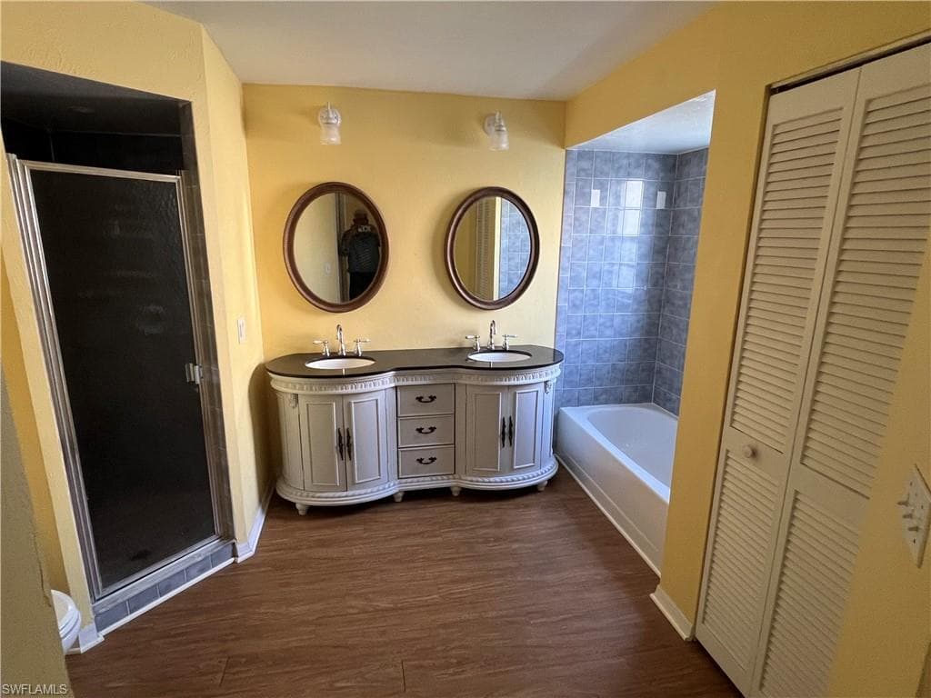 Primary Bathroom with dual sinks, walk in shower and tub. Also shows 1 of the 2 walk in closets.