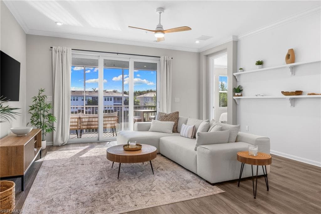 Living room with a ceiling fan, wood finished floors, and ornamental molding