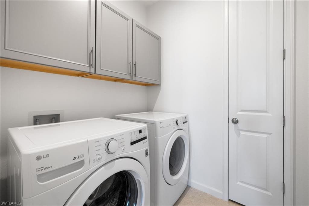 Washroom featuring washer and dryer and cabinet space