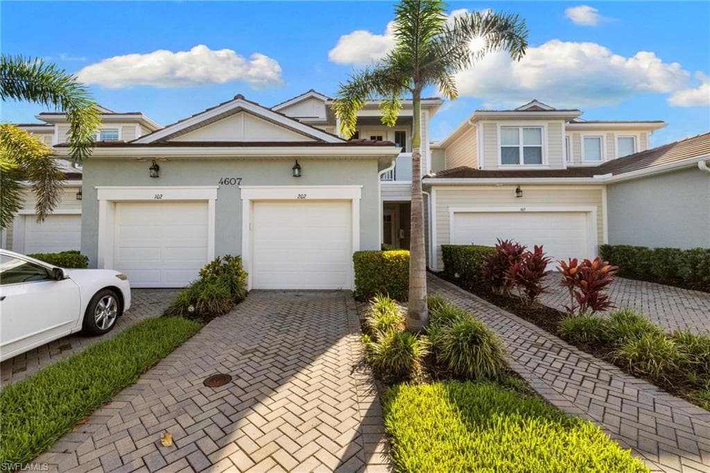 Traditional home with stucco siding and decorative driveway