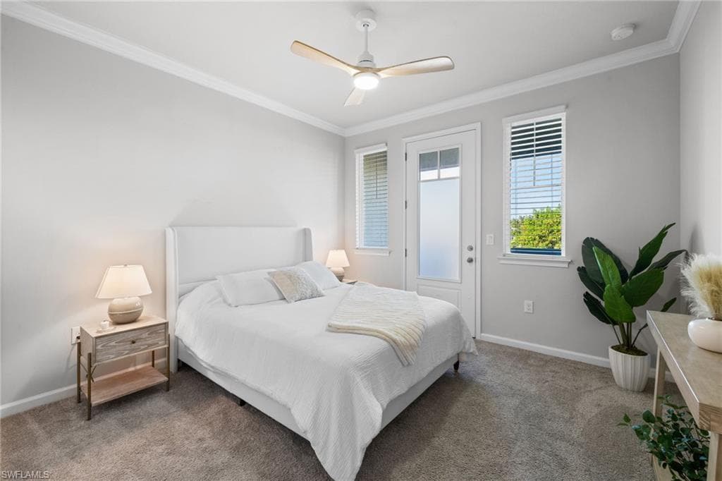 Carpeted bedroom with crown molding and a ceiling fan