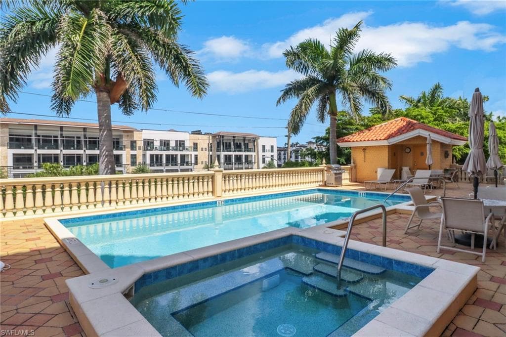 Community pool featuring a patio area, a community hot tub, and grilling area
