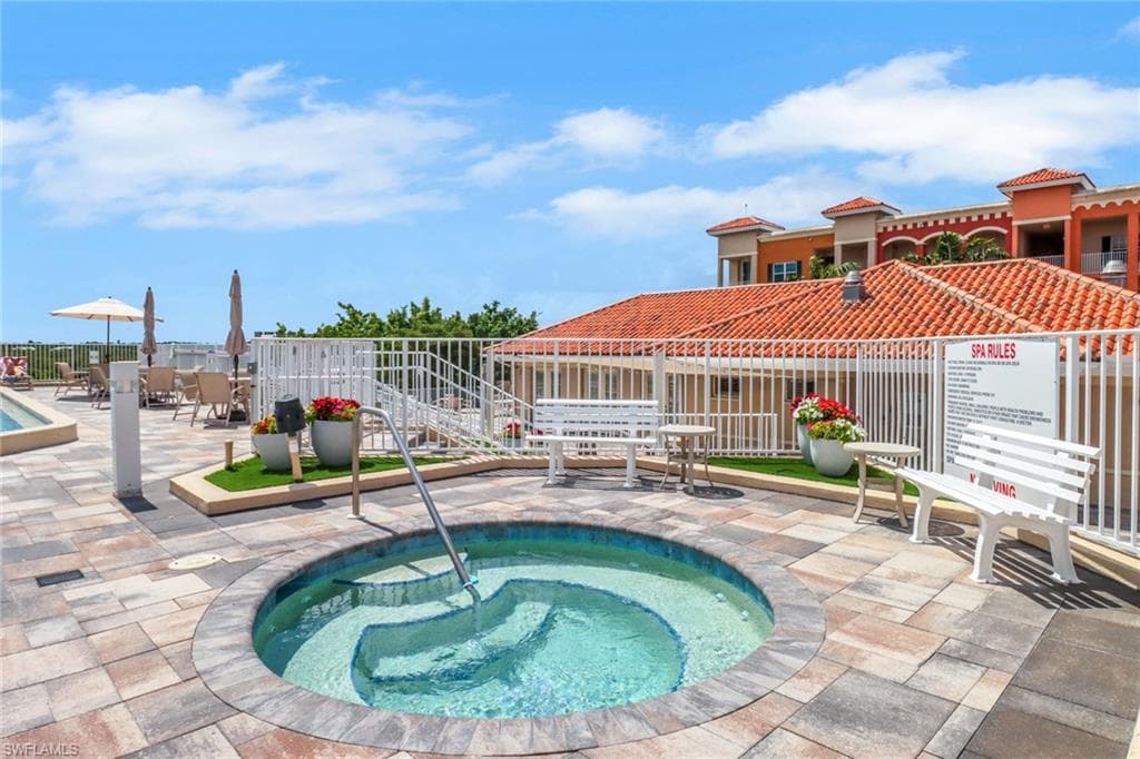 View of pool with a hot tub, a swimming pool, and a patio area