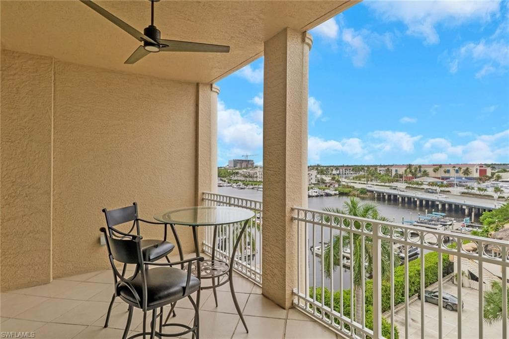 Balcony featuring ceiling fan, a sunroom, and a water view