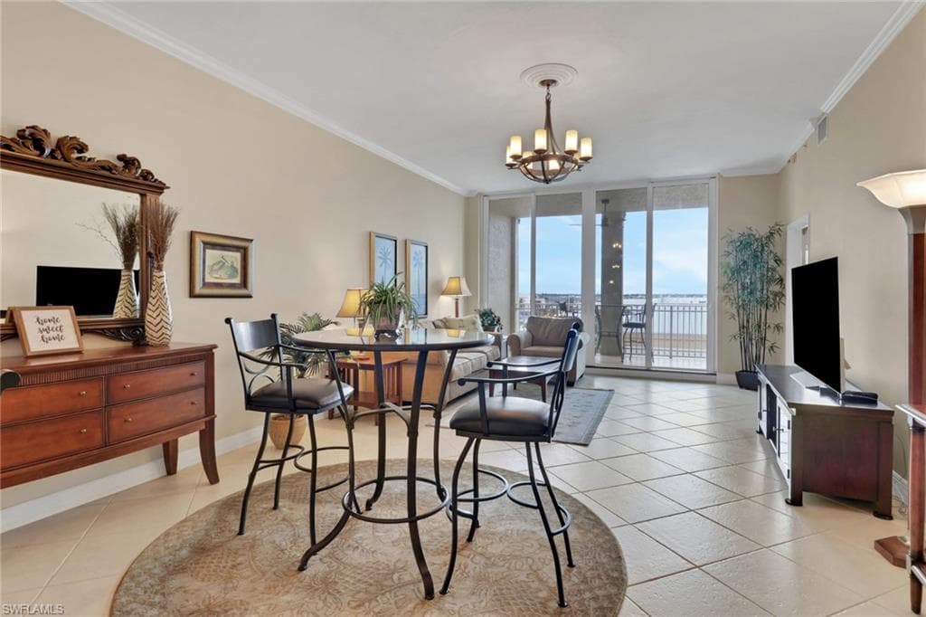 Dining room featuring a wall of windows, crown molding, light tile patterned floors, and a chandelier