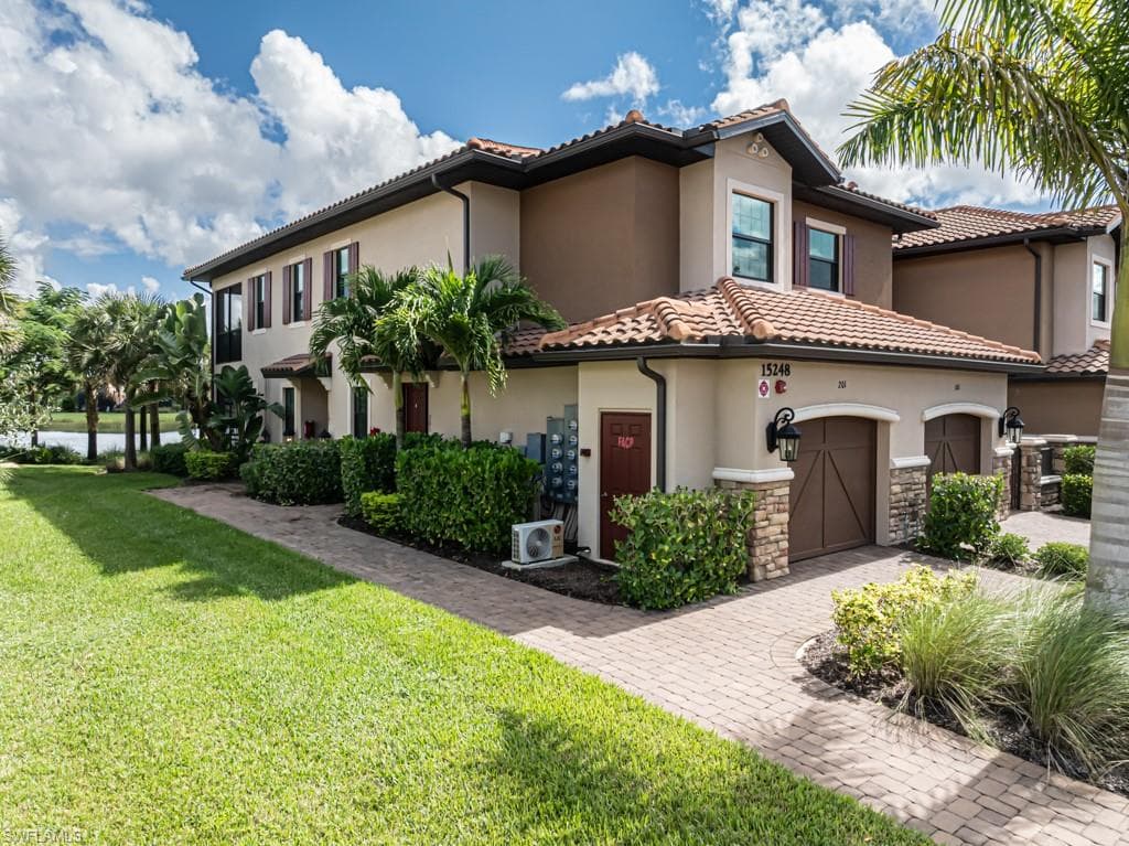 Mediterranean / spanish-style house featuring a front lawn, stucco siding, decorative driveway, and an attached garage