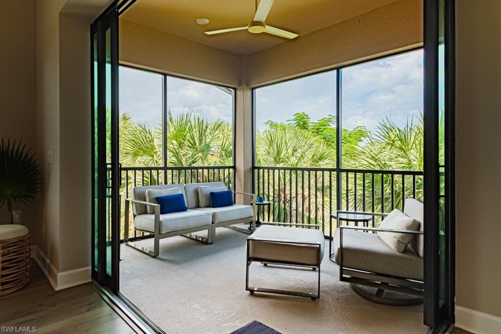 Sunroom featuring baseboards and wood finished floors