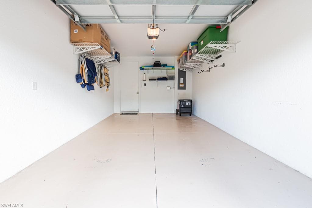 Garage featuring electric panel and a garage door opener