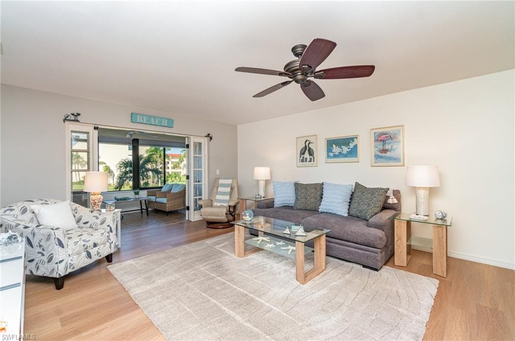 Living room with light LVP flooring with french doors to lanai