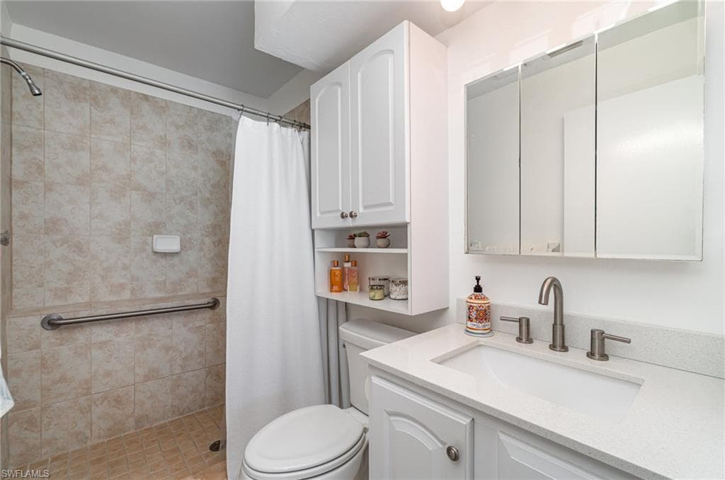 Bathroom featuring quartz counter and easy step-in shower