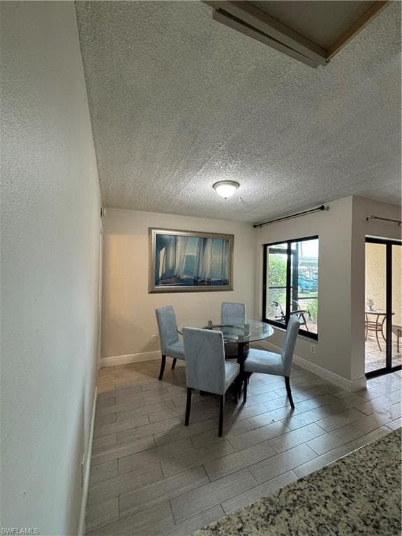 Dining room with wood tiled floors and a textured ceiling