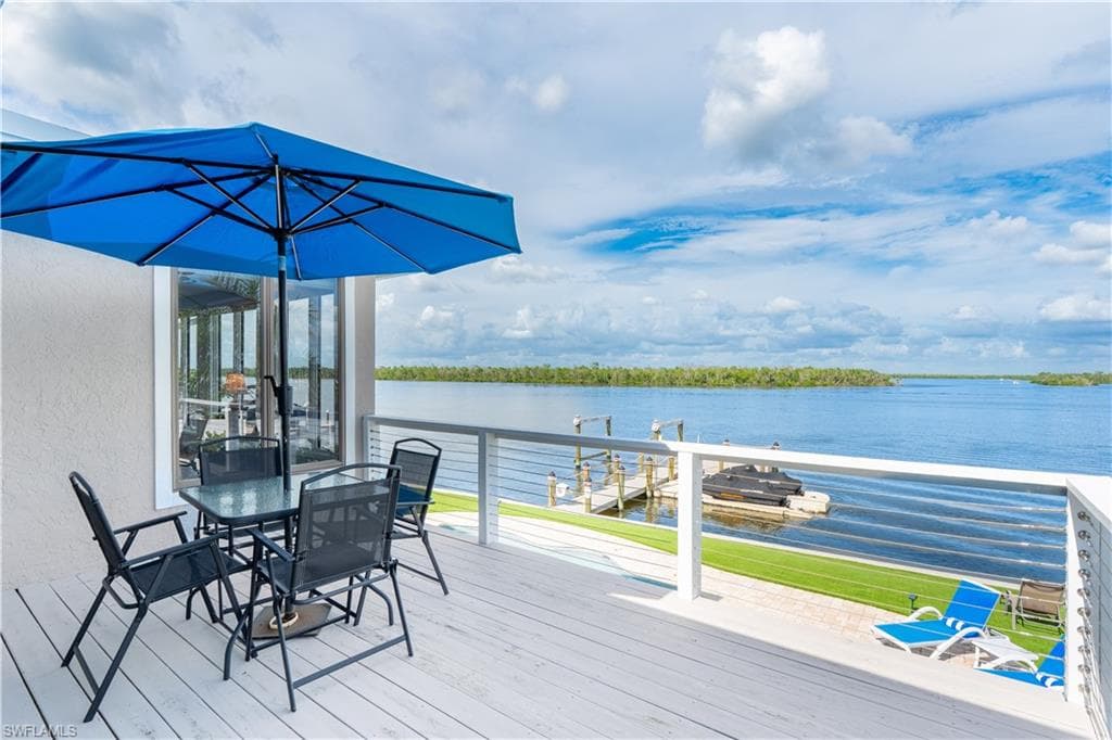 Deck with a water view and outdoor dining space - Virtually Edited Image