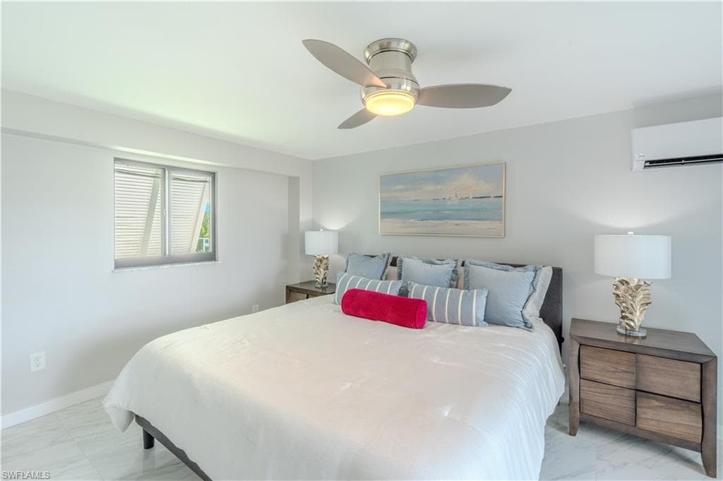 Bedroom with light marble finish floors, a wall mounted AC, and ceiling fan - Virtually Edited Image