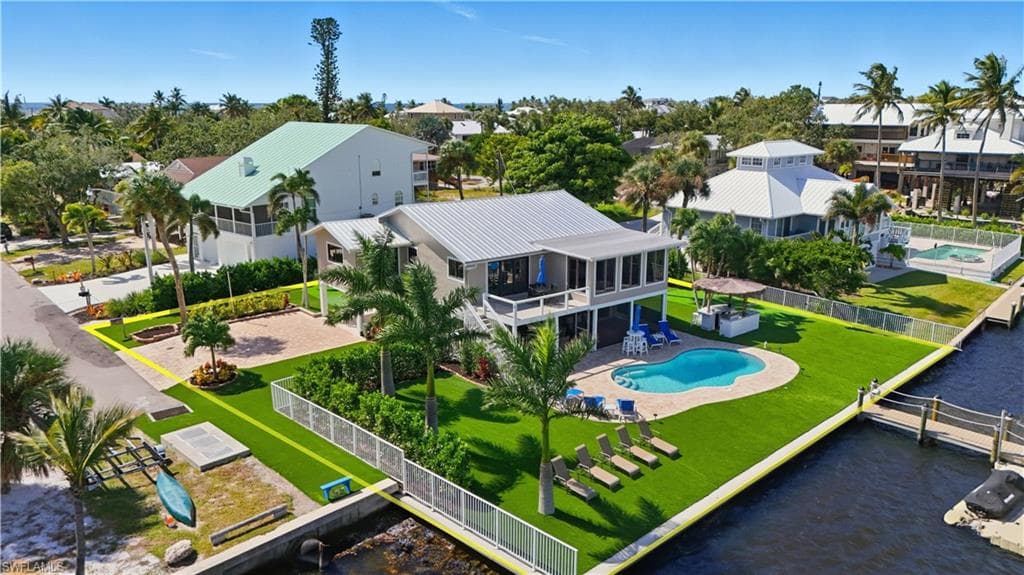 Aerial view of residential area featuring a pool and bay views - Virtually Edited Image