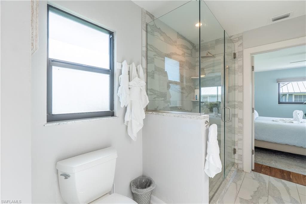 Bathroom featuring connected bathroom, a shower stall, and marble finish floors - Virtually Edited Image