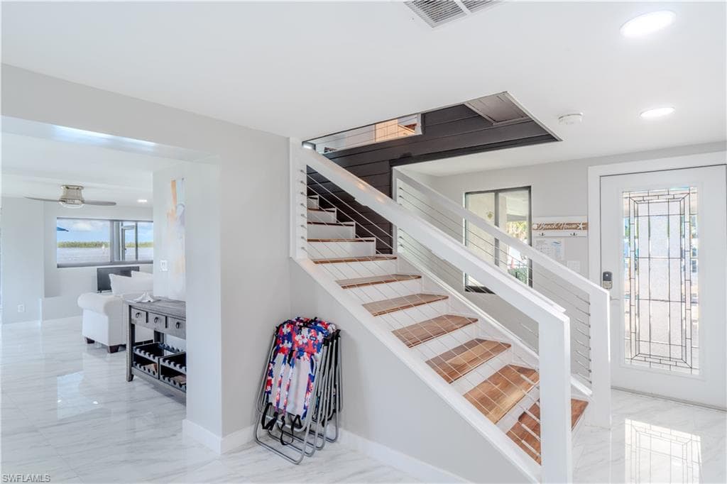 Staircase featuring healthy amount of natural light, tiled flooring, and recessed lighting - Virtually Edited Image