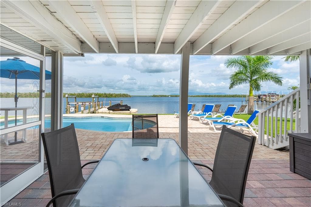 View of patio / terrace with outdoor dining space and a water view - Virtually Edited Image