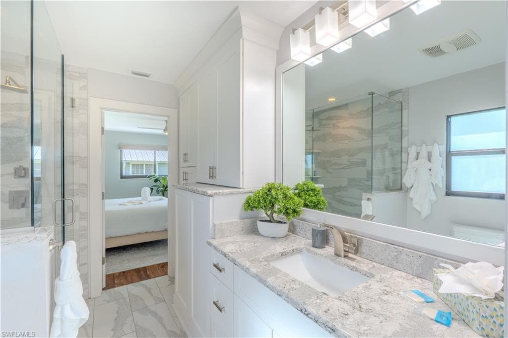 Ensuite bathroom with vanity, light marble finish flooring, a stall shower, and a bathtub - Virtually Edited Image