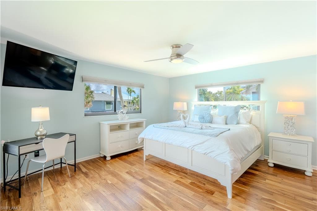 Bedroom featuring light wood-style floors and a ceiling fan - Virtually Edited Image