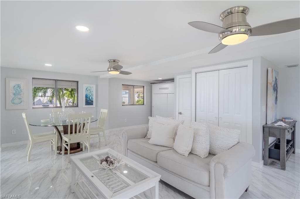 Living area featuring a ceiling fan, recessed lighting, plenty of natural light, and light tile finish flooring - Virtually Edited Image