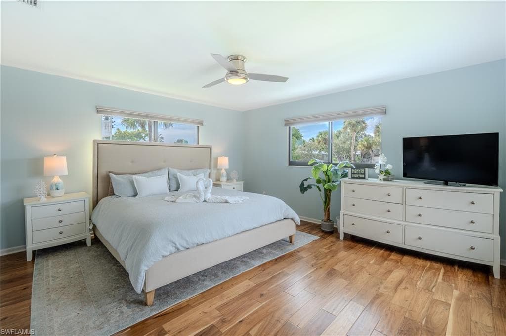 Bedroom with light wood-style floors and ceiling fan - Virtually Edited Image