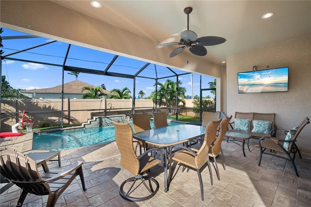 Fenced backyard featuring glass enclosure, a sunroom, a patio, and a hot tub