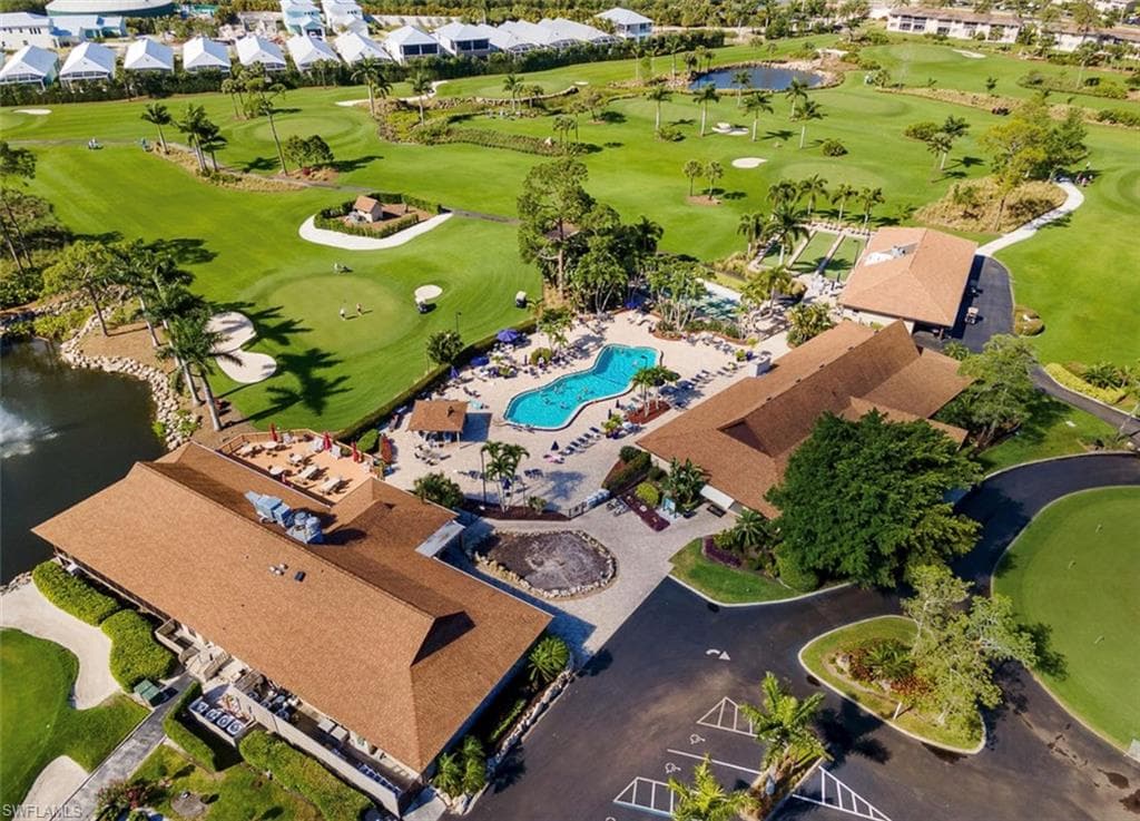 Aerial view of residential area featuring a nearby body of water and a golf course