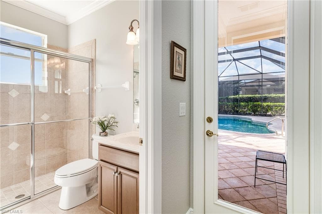 Bathroom with ornamental molding, vanity, a shower stall, and light tile patterned flooring