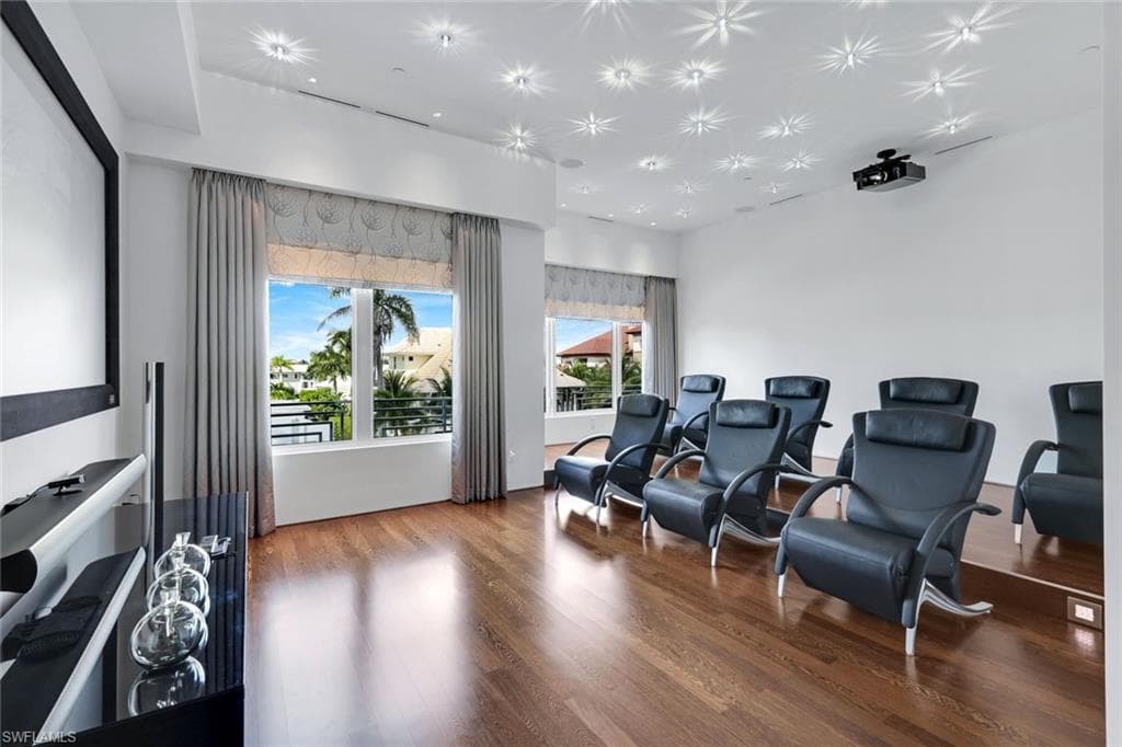 Cinema room with Swarovski crystal lighting, 120" 3D projector, Bang & Olufsen audio, and walnut floors.