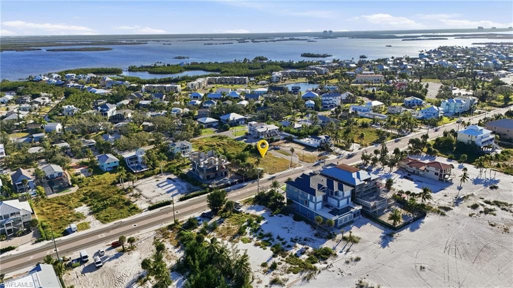 Aerial view of property and surrounding area featuring nearby suburban area and a nearby body of water - Virtually Edited Image