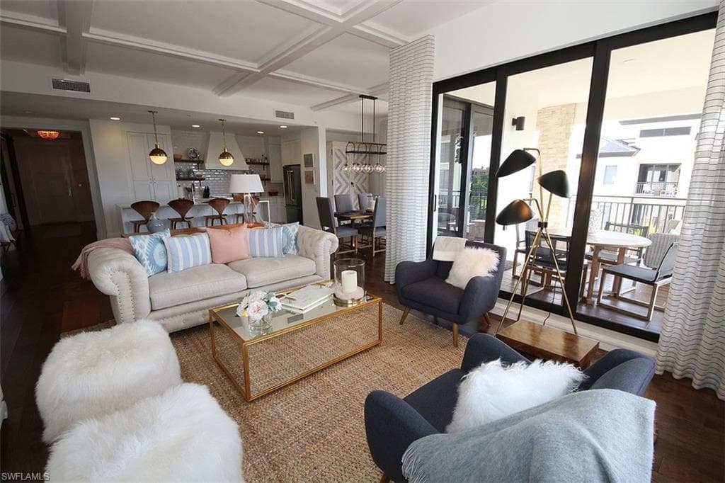 Living area featuring wood finished floors, coffered ceiling, beamed ceiling, and a chandelier