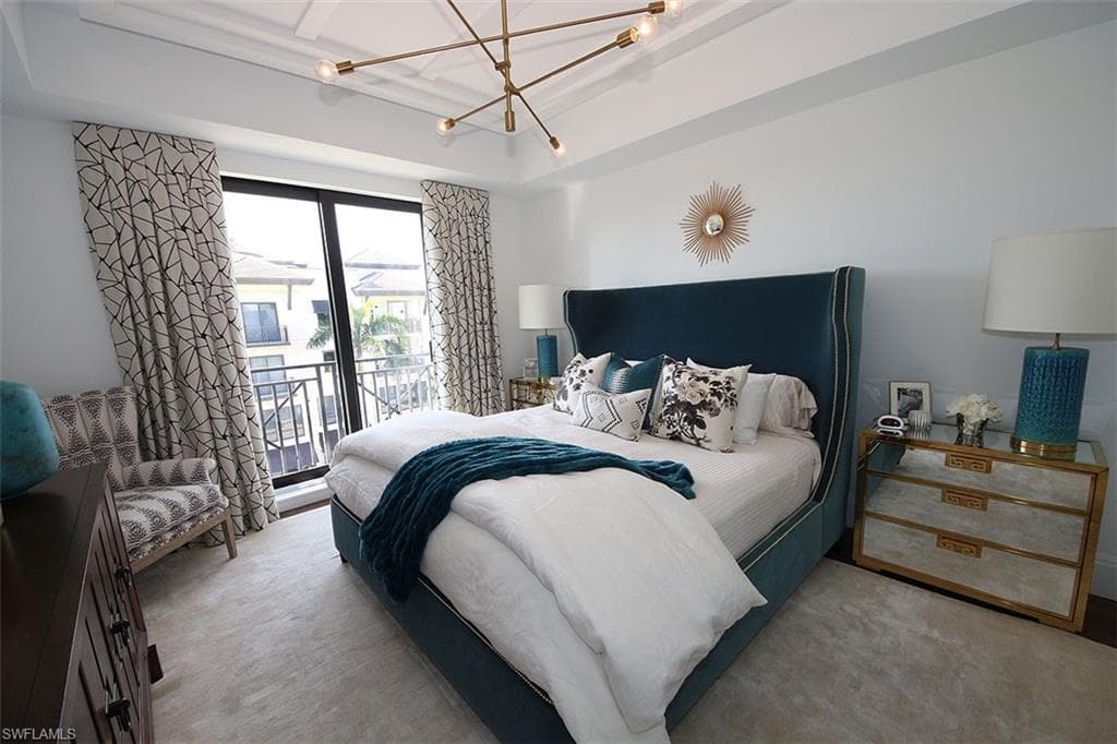 Bedroom with access to outside and a chandelier
