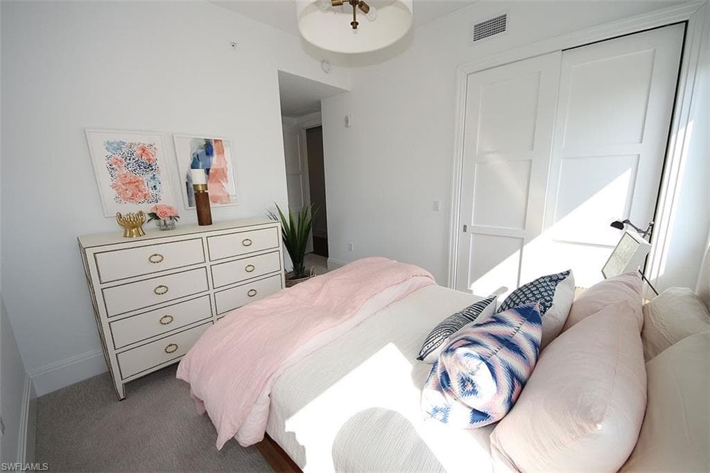 Carpeted bedroom with baseboards and a closet