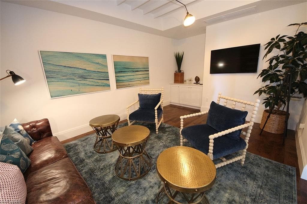 Living area featuring beam ceiling and dark wood-type flooring