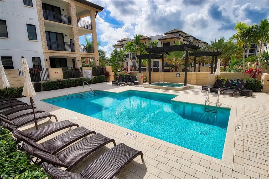 Community pool featuring a community hot tub, a patio area, and a pergola