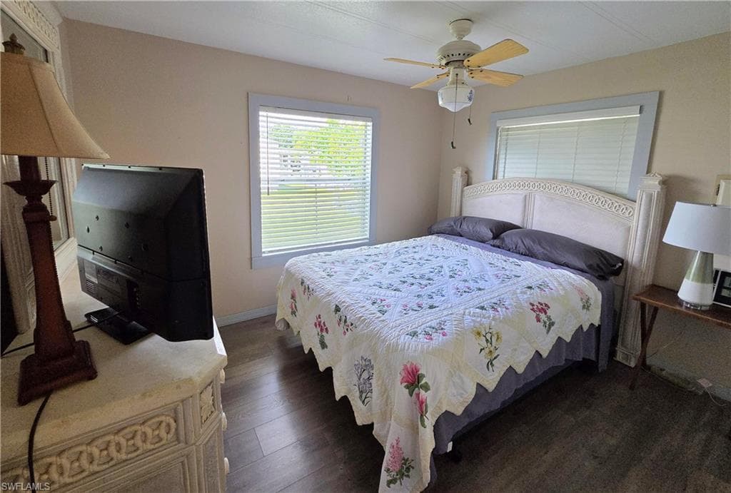 Guest bedroom with ceiling fan and laminate floors.