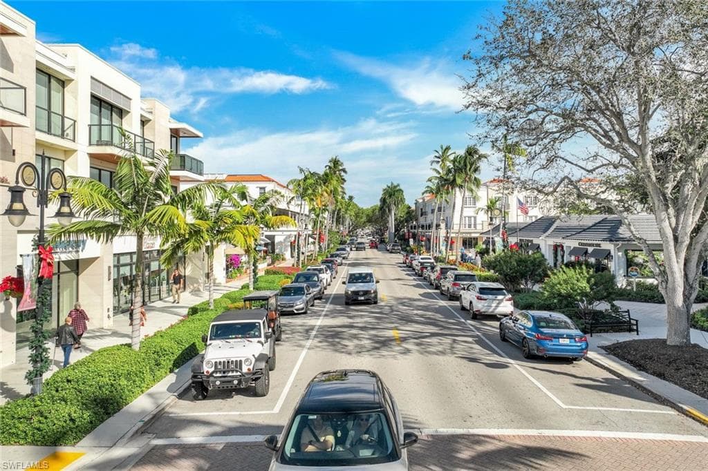 View of asphalt street with sidewalks, street lighting, and curbs