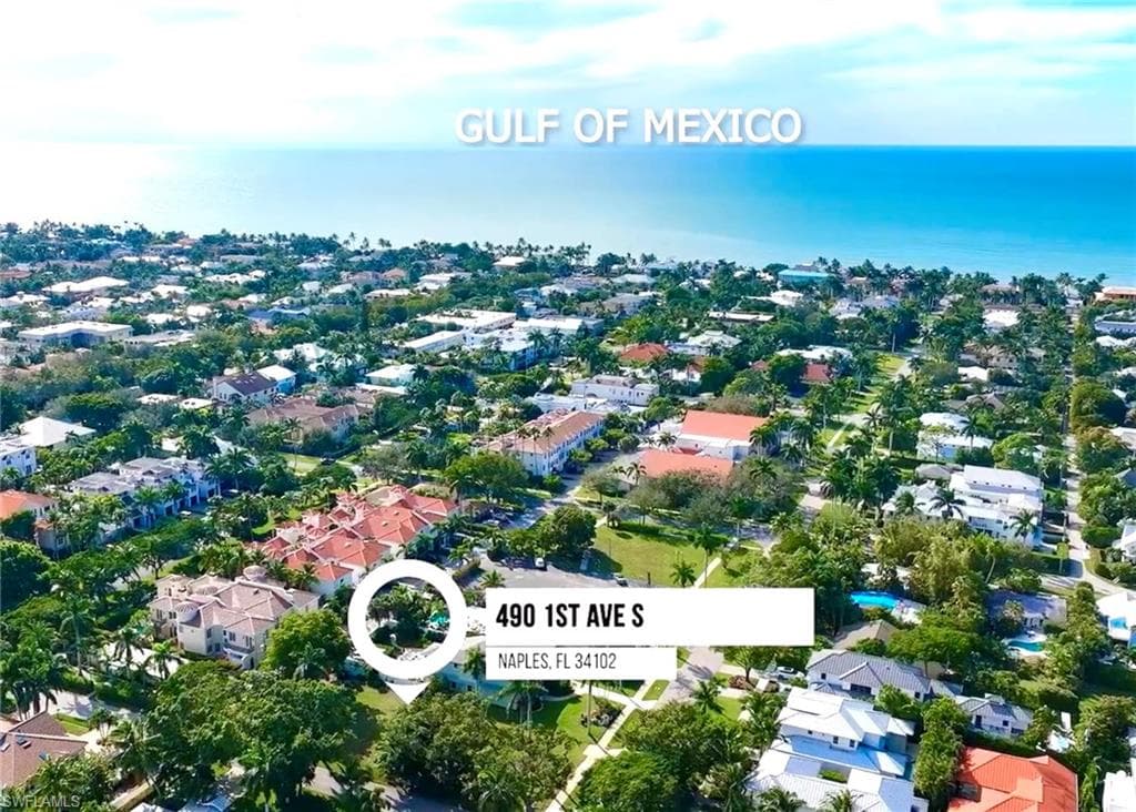 Aerial view of property's location featuring a large body of water and nearby suburban area