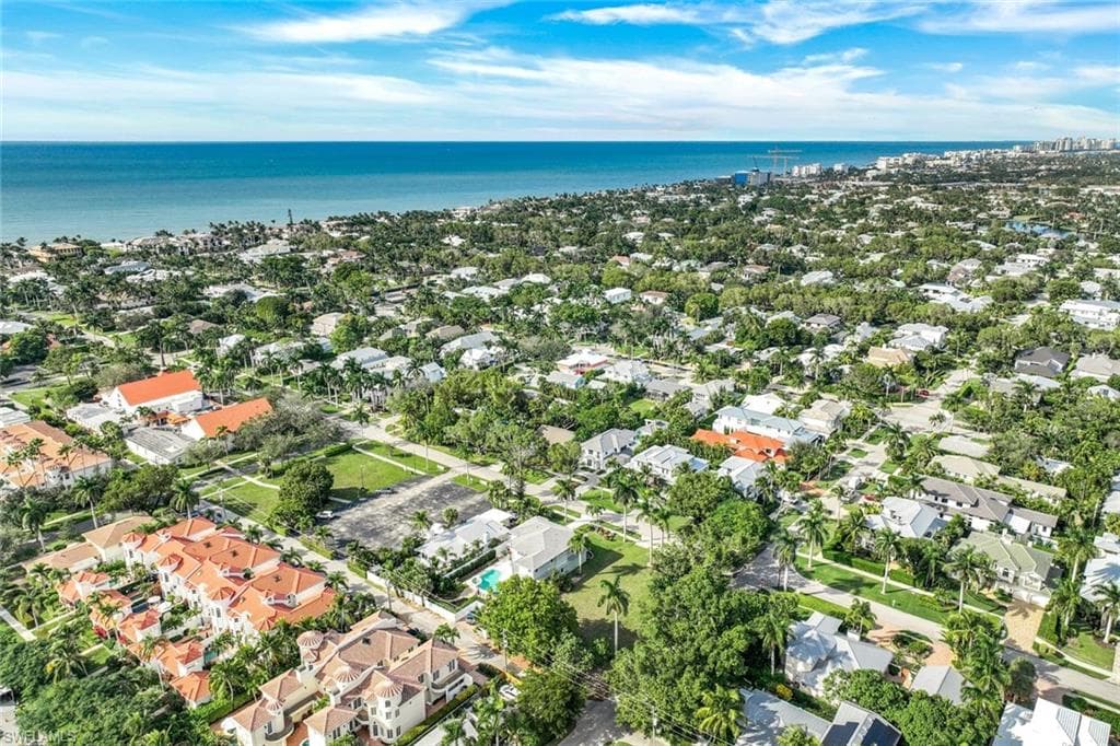 Aerial view of property and surrounding area with a nearby body of water and nearby suburban area