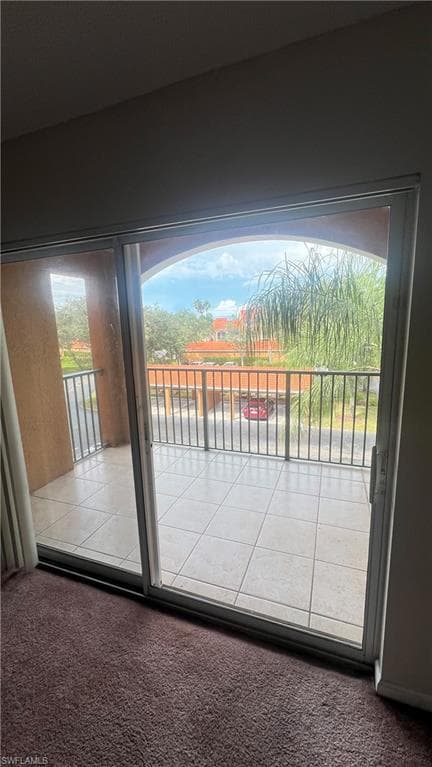 Doorway to outside with carpet and healthy amount of natural light