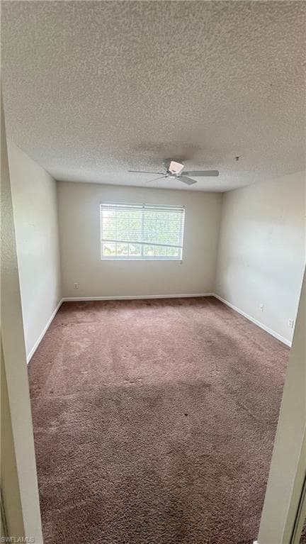 Empty room featuring carpet and a textured ceiling