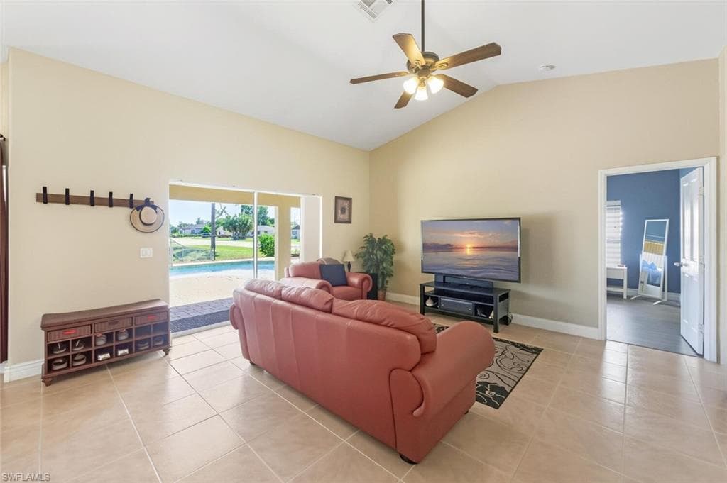Living room featuring ceiling fan, light tile patterned floors, and high vaulted ceiling