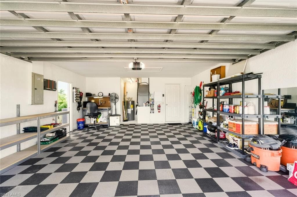 Garage featuring electric panel, water heater, and a garage door opener