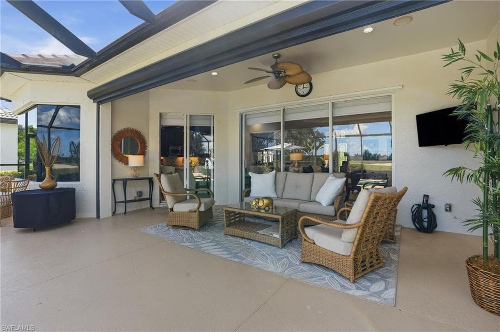 View of patio with outdoor lounge area, a ceiling fan, and a sunroom