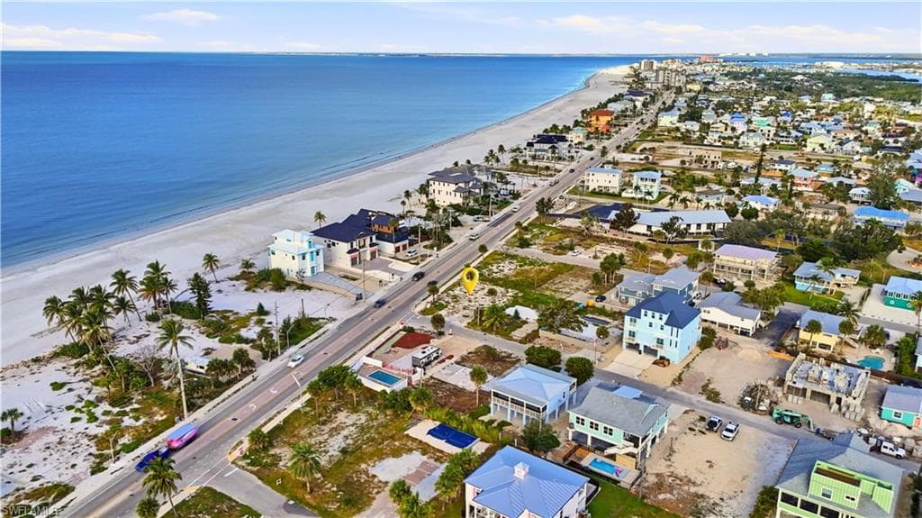 Aerial view of property and surrounding area featuring unending shoreline and nearby suburban area - Virtually Edited Image