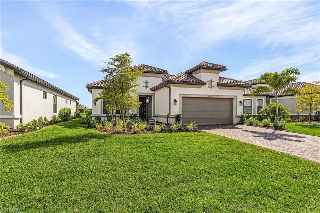Mediterranean / spanish house with a garage and a front yard