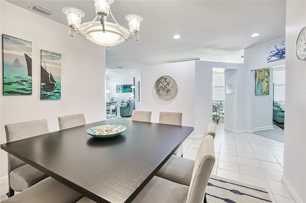 Dining area featuring a chandelier, light tile patterned floors, and recessed lighting