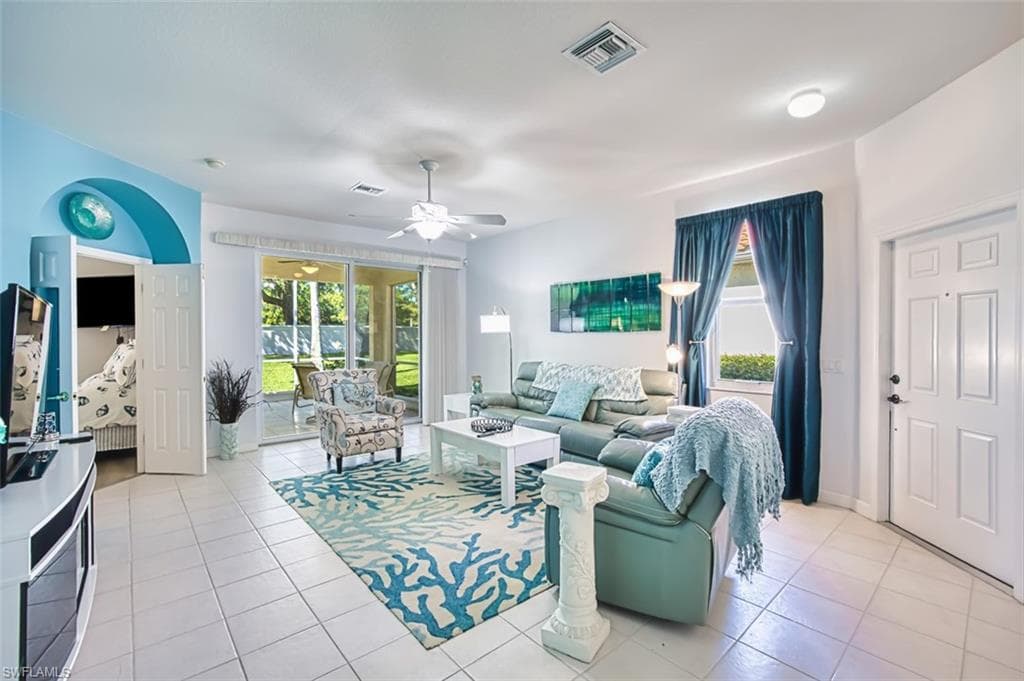 Living room featuring light tile patterned floors and a ceiling fan