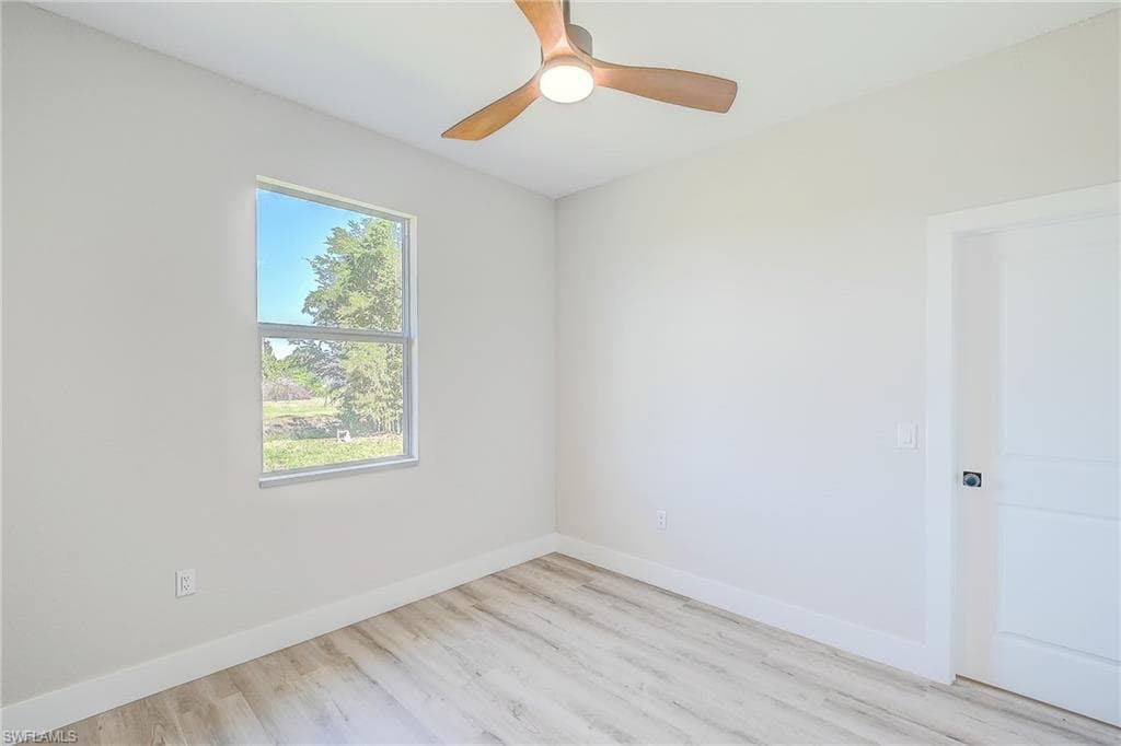 Spare room featuring light wood-style floors and a ceiling fan