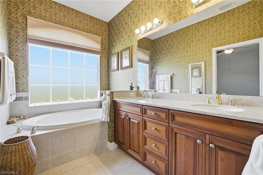 Primary Bathroom with privacy window, soaking tub, dual sinks and vanity